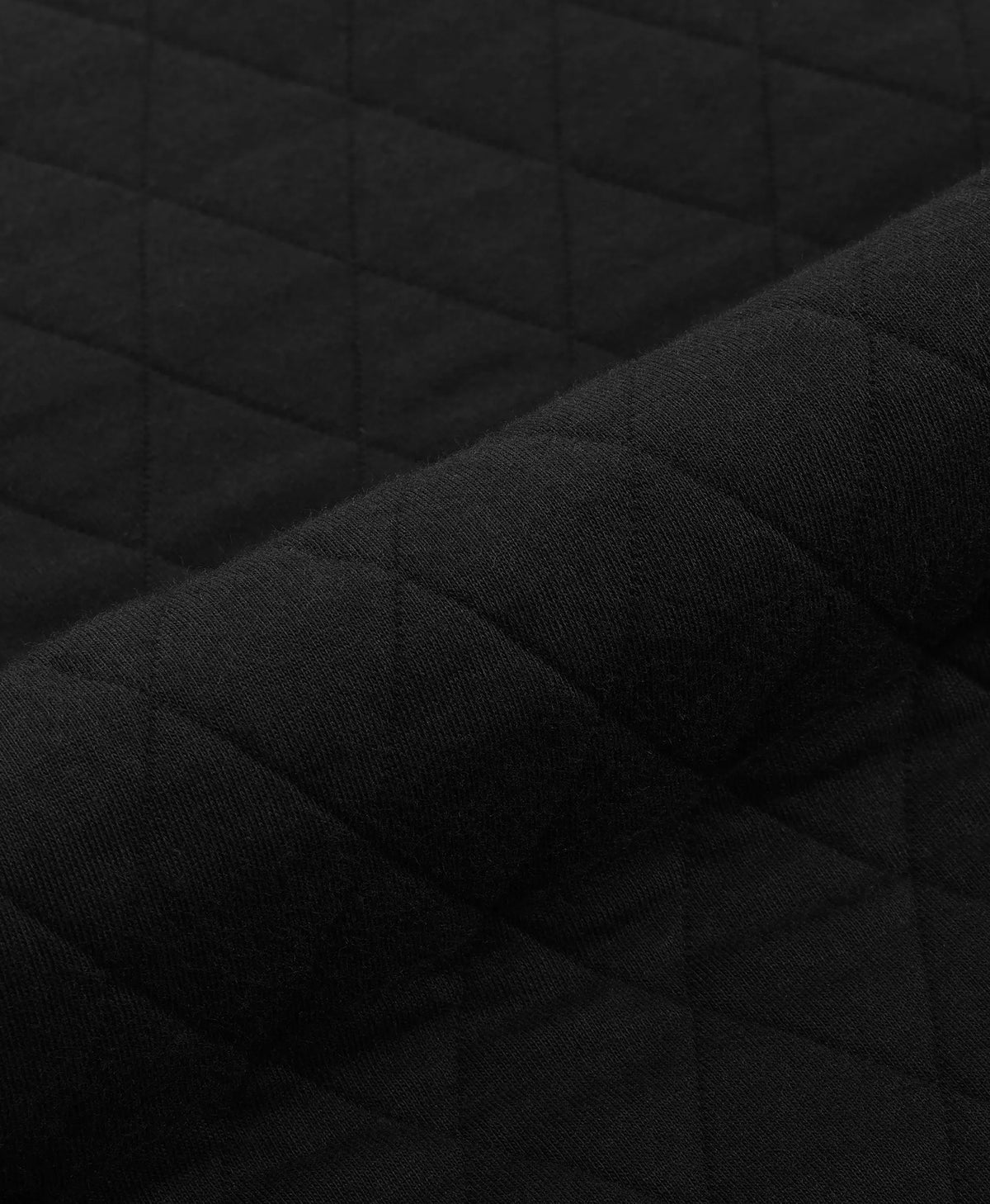 Close-up of the black quilted fabric texture on an ororo heated pullover.