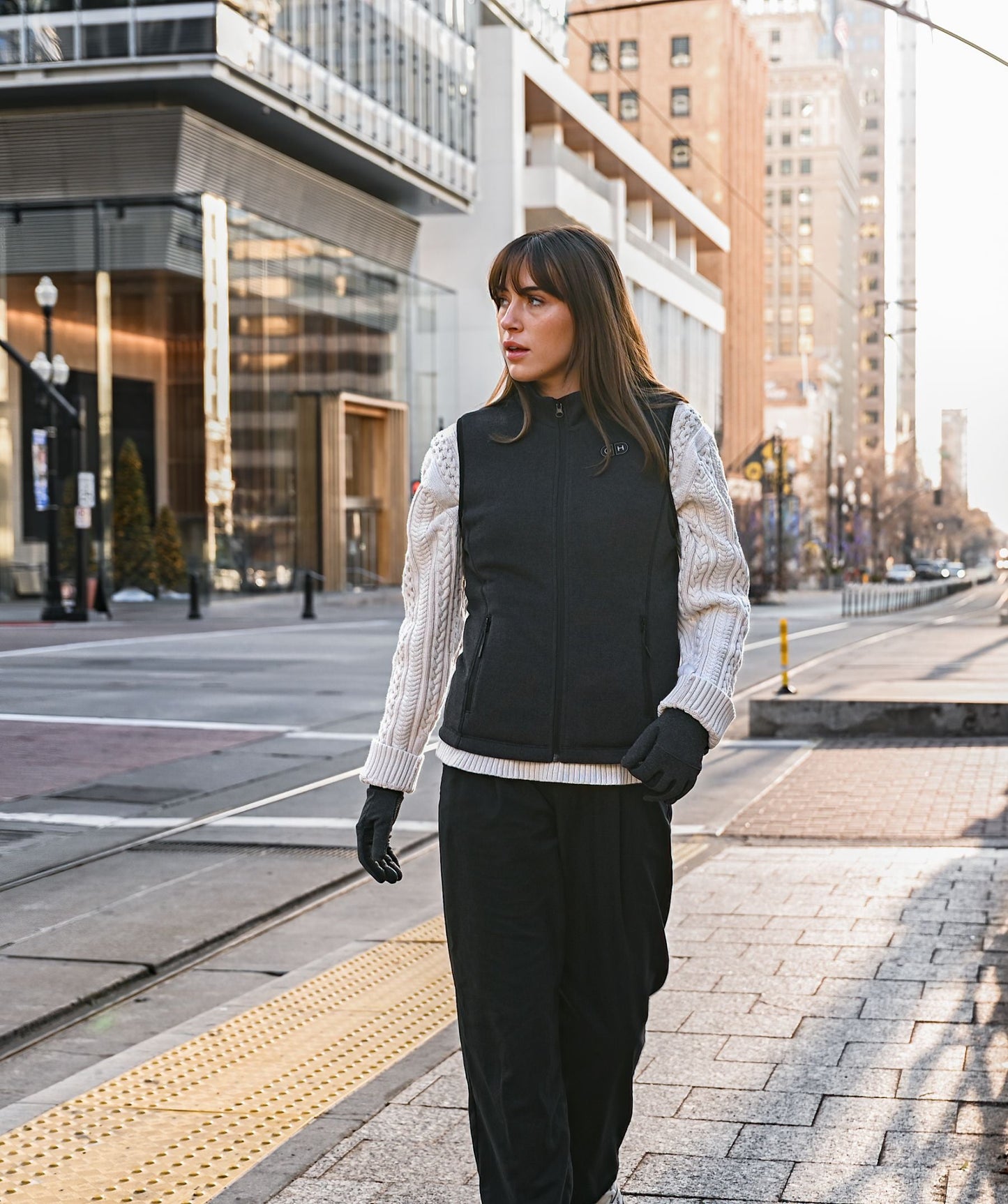 OH-1 Women’s Heated Recycled Fleece Vest- product usage scenario illustration- woman walking in the city