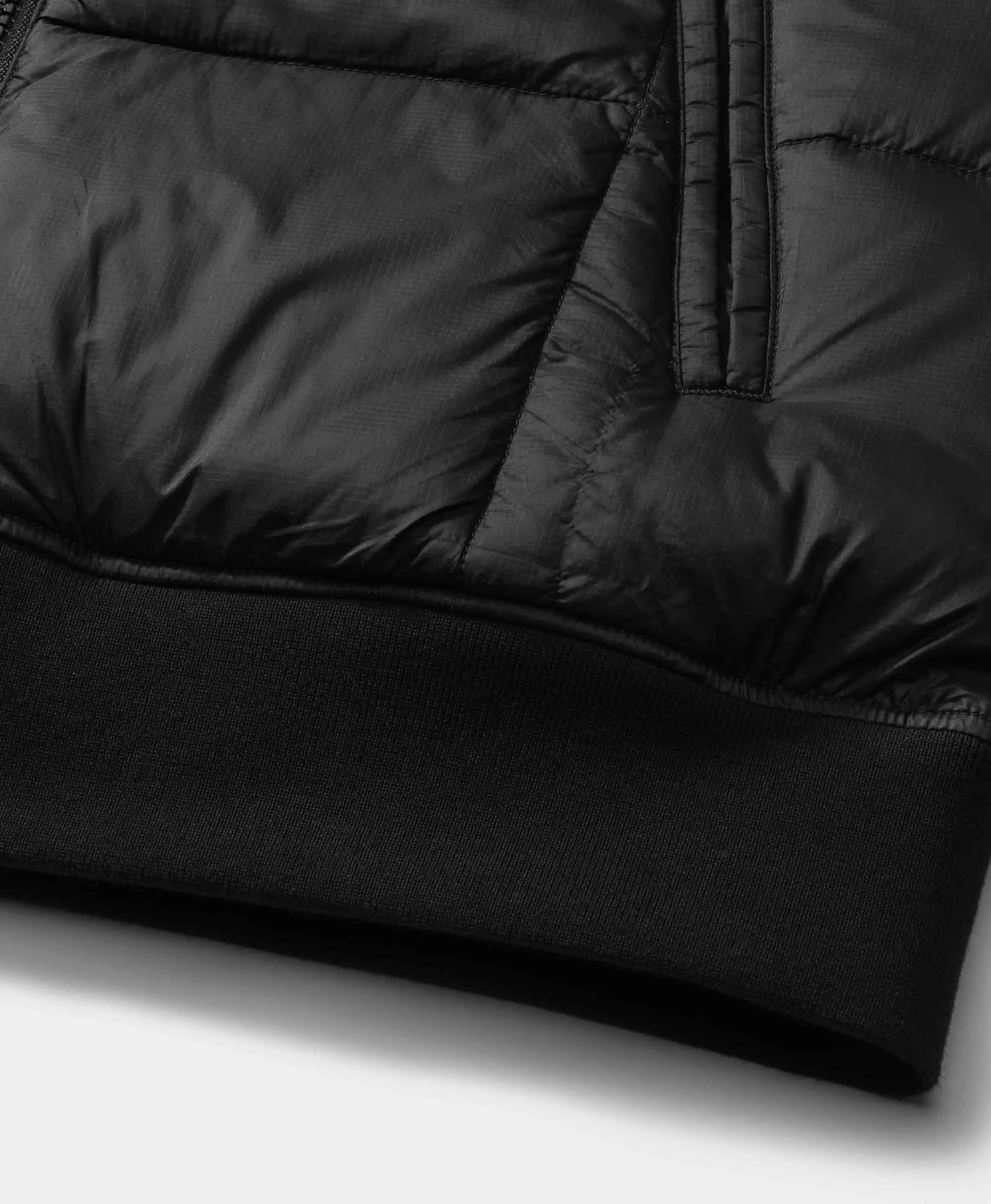 The hem is constructed with a ribbed finish to enhance fit and elasticity, providing a secure seal against cold air intrusion.