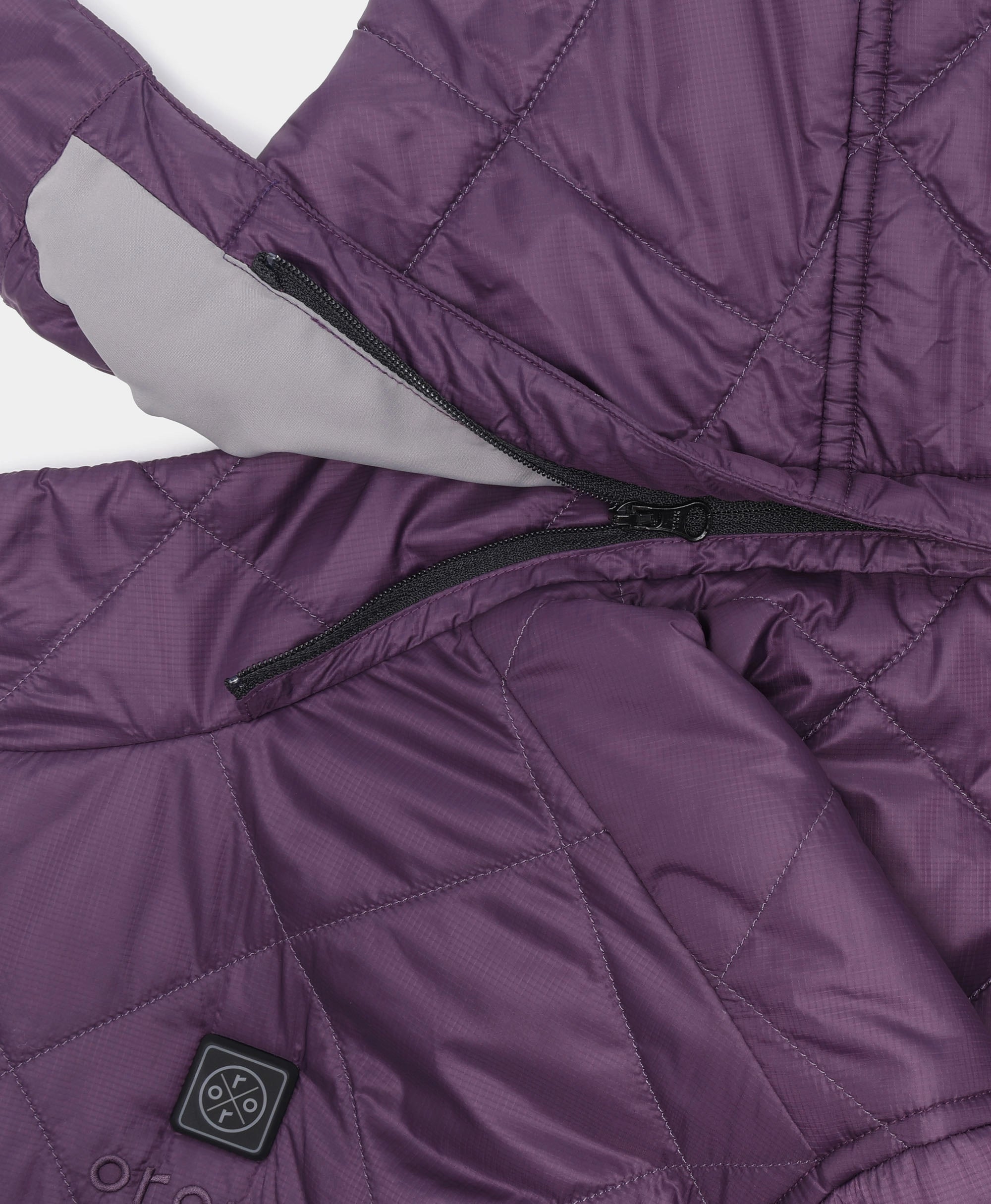 Close-up of a purple quilted puffer jacket with a black zipper