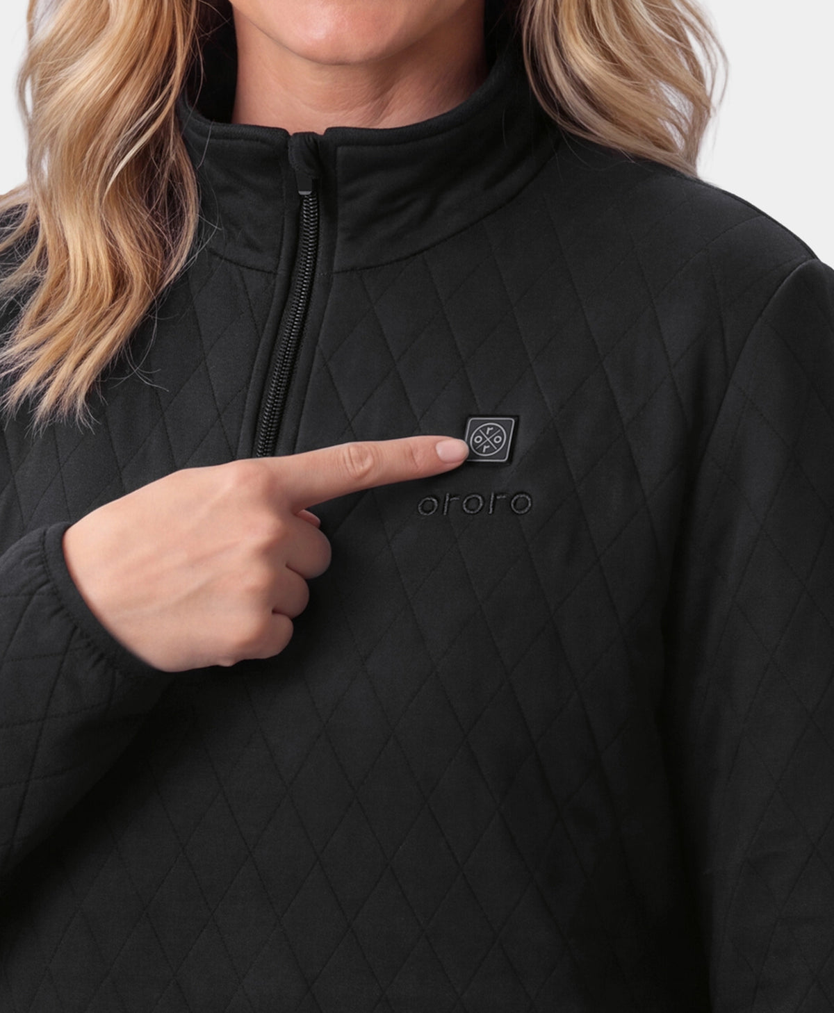 Close-up of a hand pointing to the power button on an ororo black quilted heated jacket.