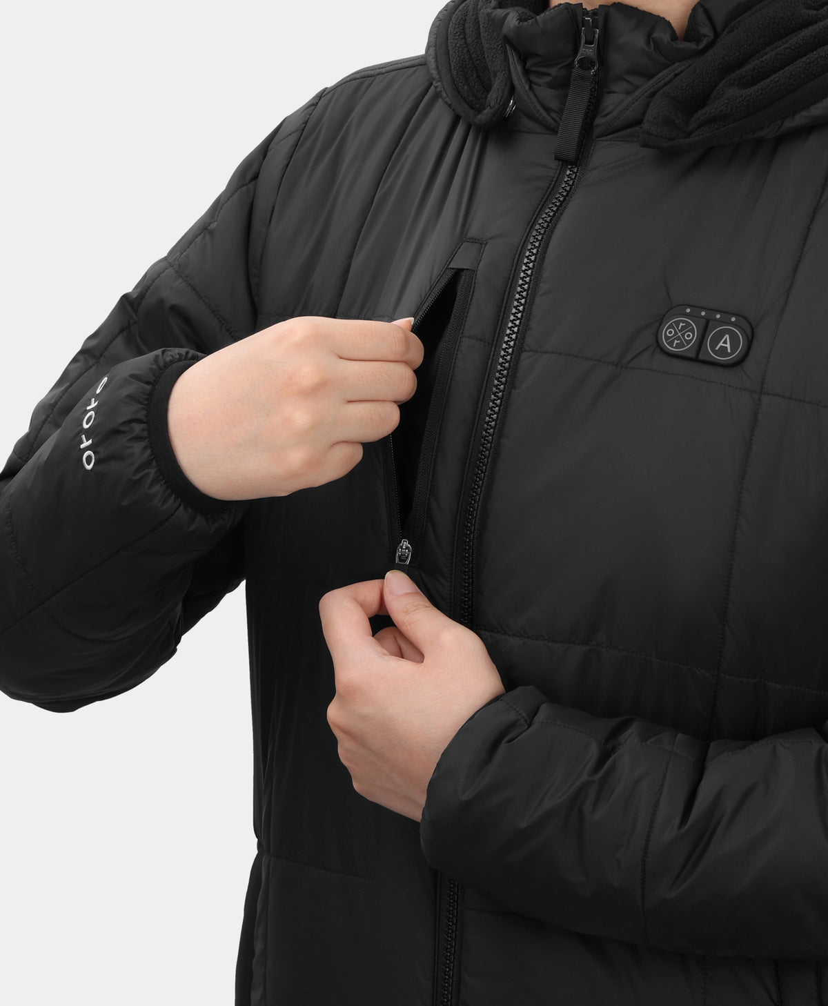 Close-up of Overland Women's 7-Zone Heated Jacket showing zippered chest pocket, power button, and sleeve branding