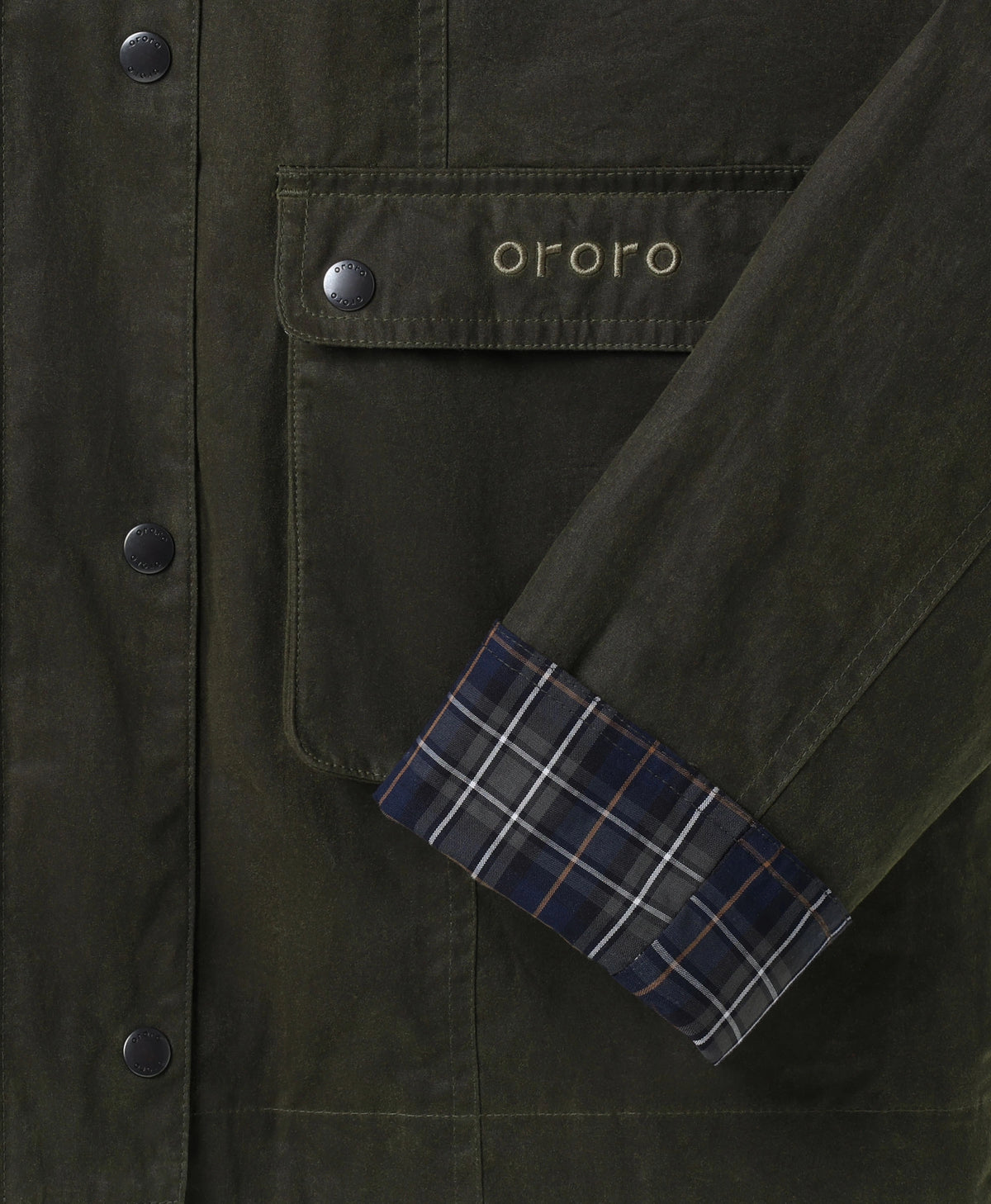 Close-up of ororo jacket flap pocket with branded logo and plaid cuff detail