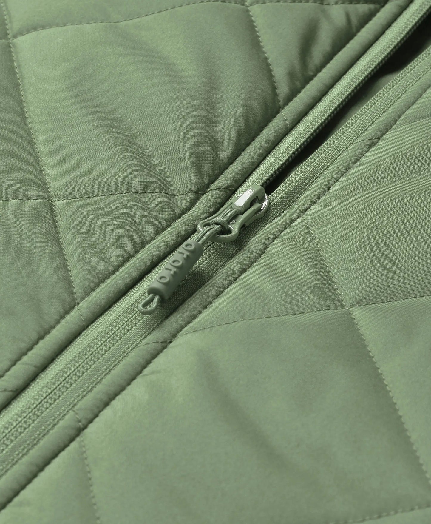 Close-up of hedge green ororo Women's Heated Quilted Vest front zipper featuring an embossed ororo logo on the zipper pull tab