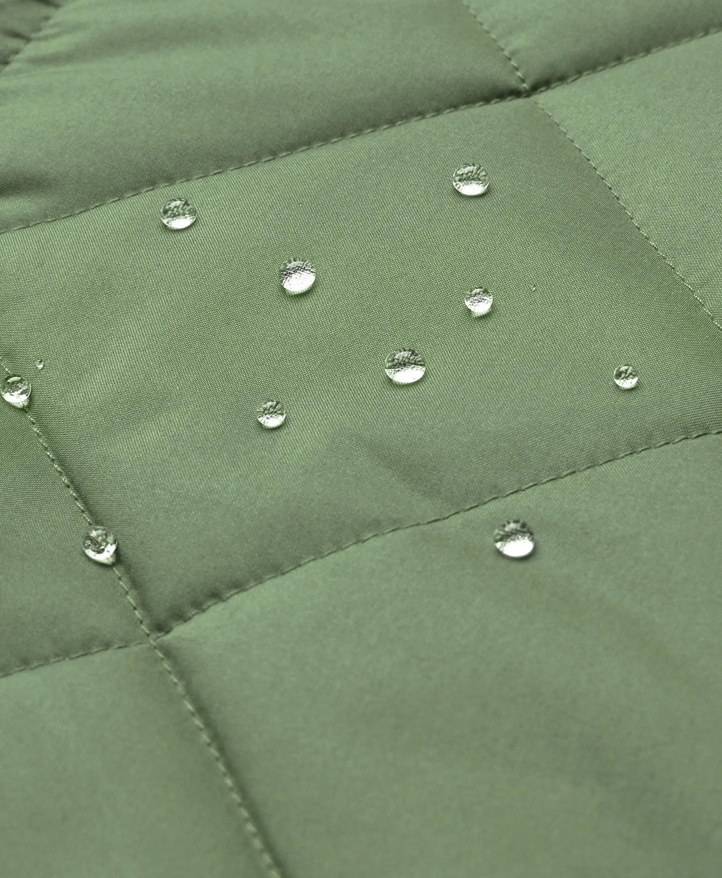 Close-up of an olive green quilted fabric surface with several clear water droplets resting on the material.