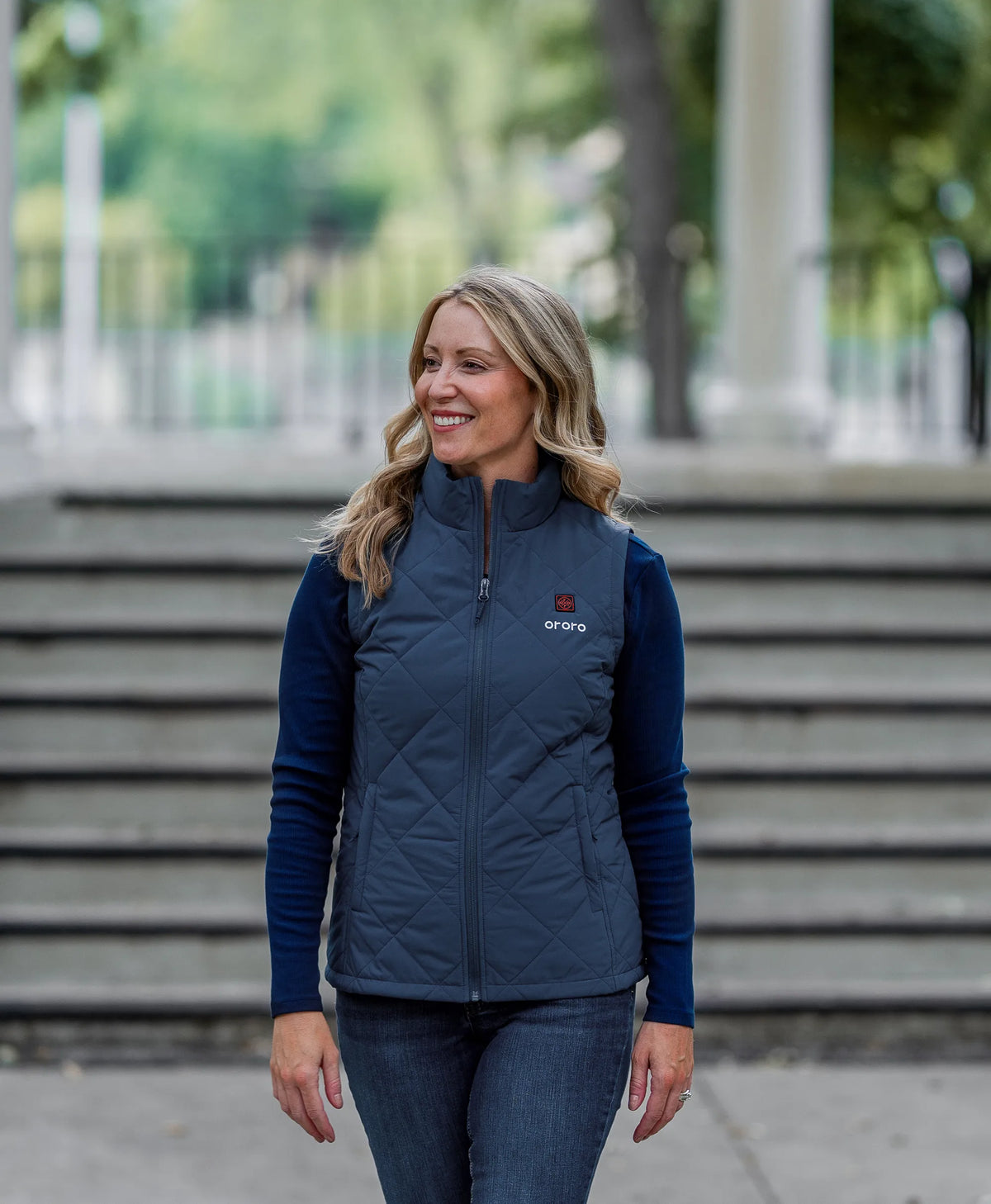 A woman wearing a navy blue quilted vest over a matching navy long-sleeve shirt