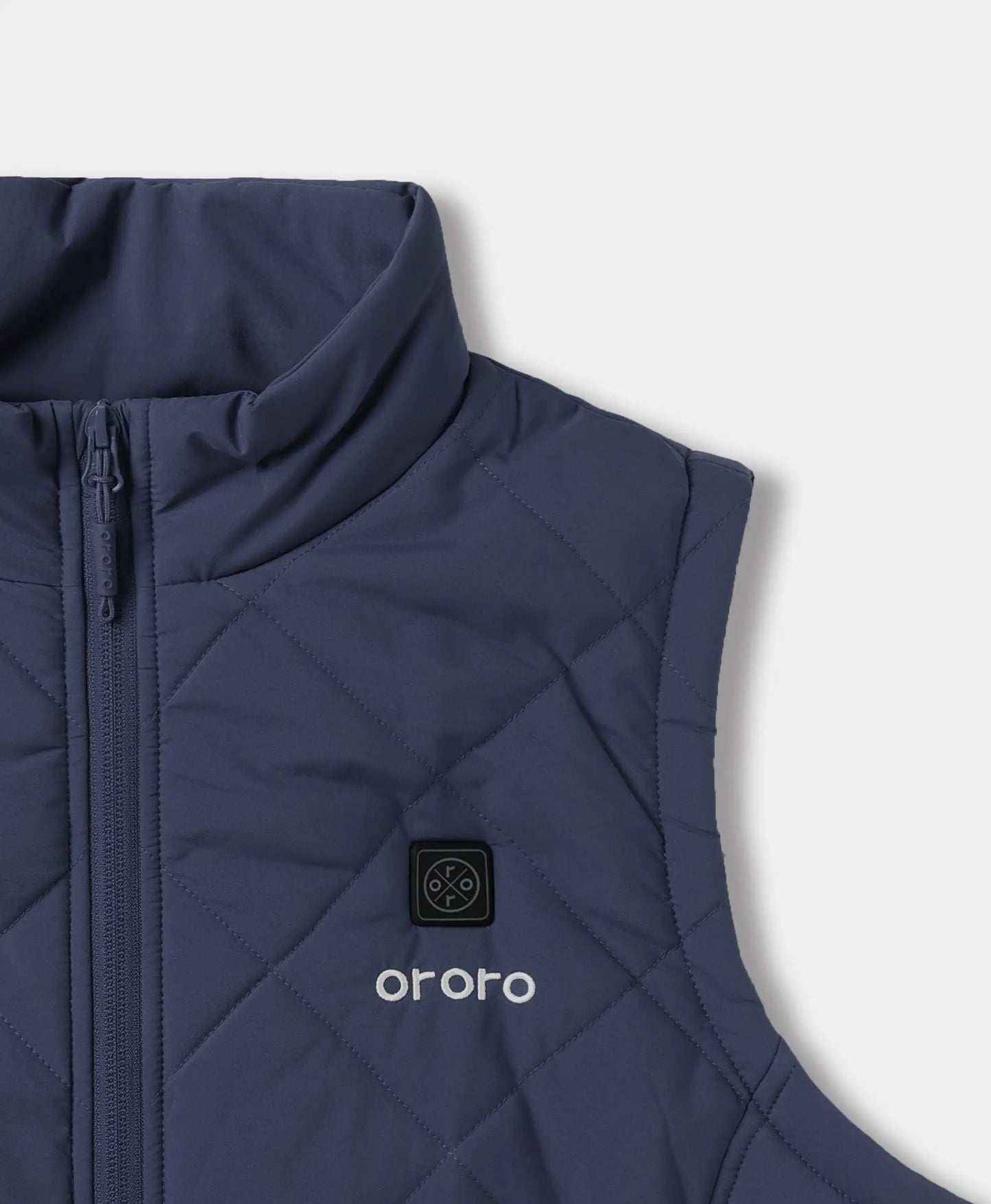 Close-up of a navy quilted puffer vest with a stand collar, front zipper, and a black square logo patch above the white 'ororo' wordmark on the chest.