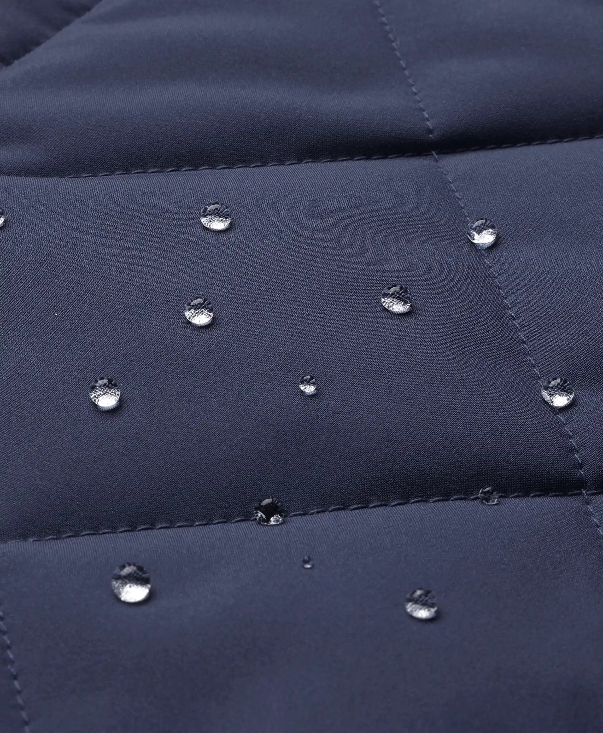 Close-up of water droplets on the water-resistant navy blue fabric of the ororo Women's Heated Quilted Vest
