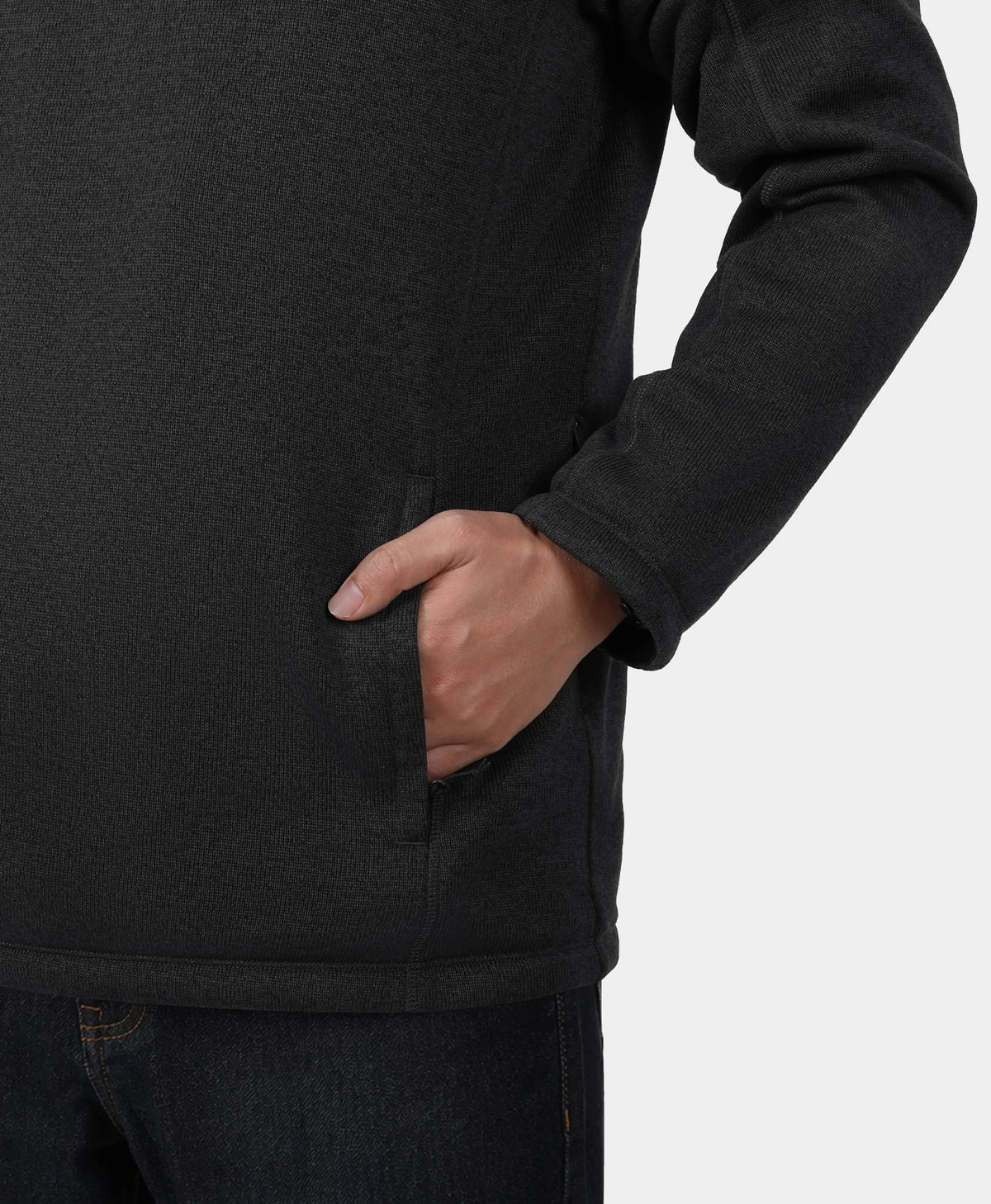 Close-up of a person wearing a dark charcoal fleece pullover with a side pocket