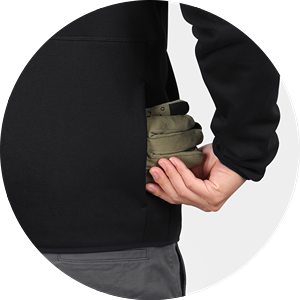 Close-up of hand slipping gloves into the side pocket of a black fleece jacket