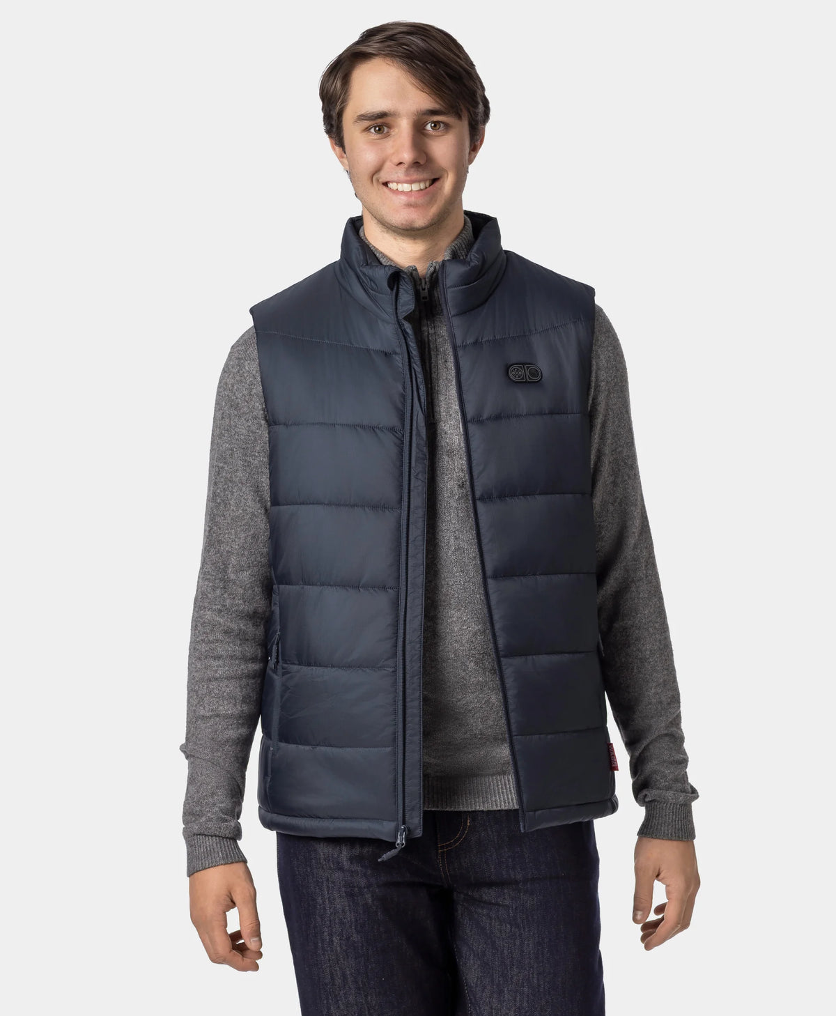 Man wearing an ororo Charcoal Slate heated puffer vest unzipped over a gray sweater, showing the layered fit