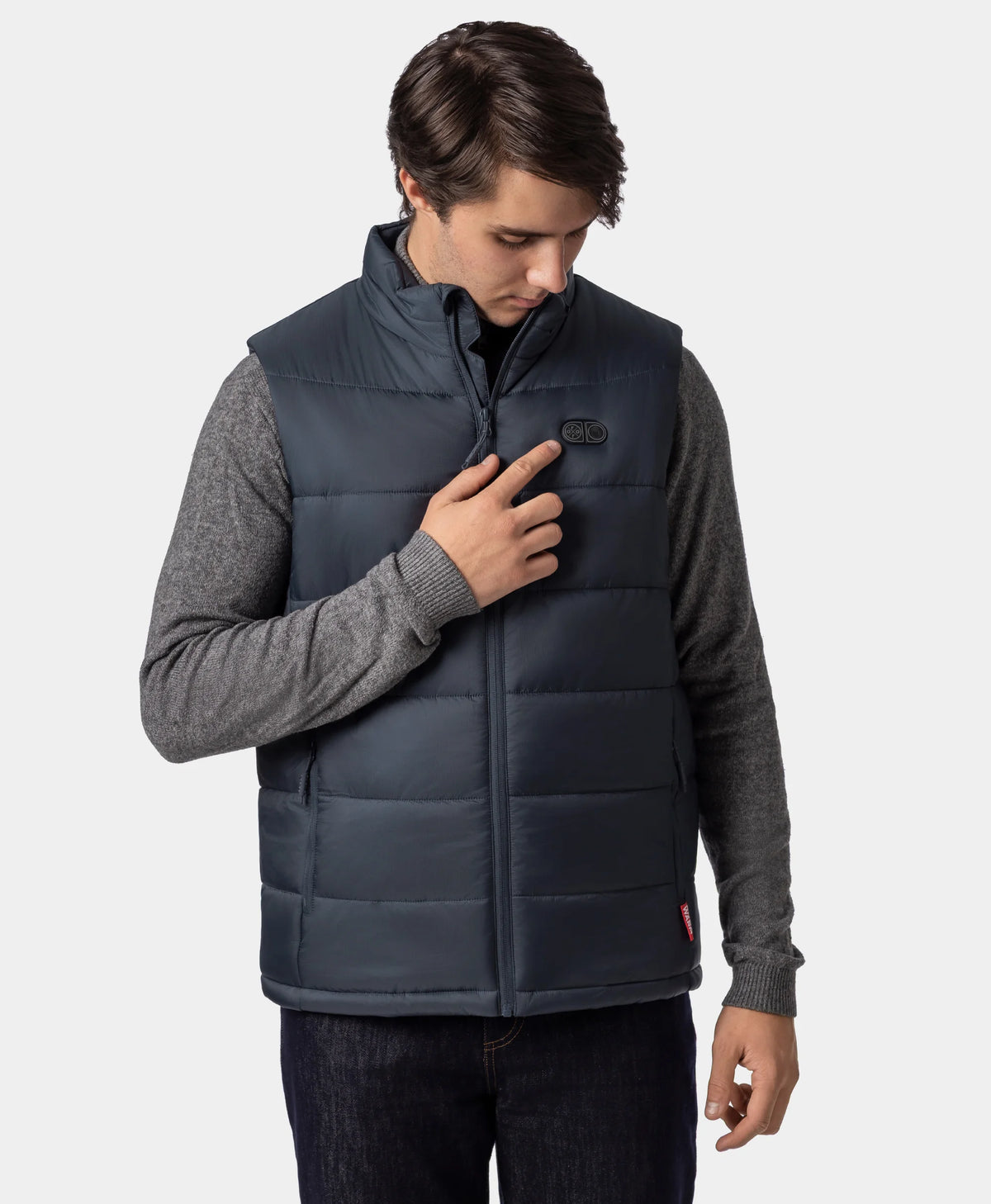Man wearing an ororo Charcoal Slate heated puffer vest while pressing the heating control button on the chest