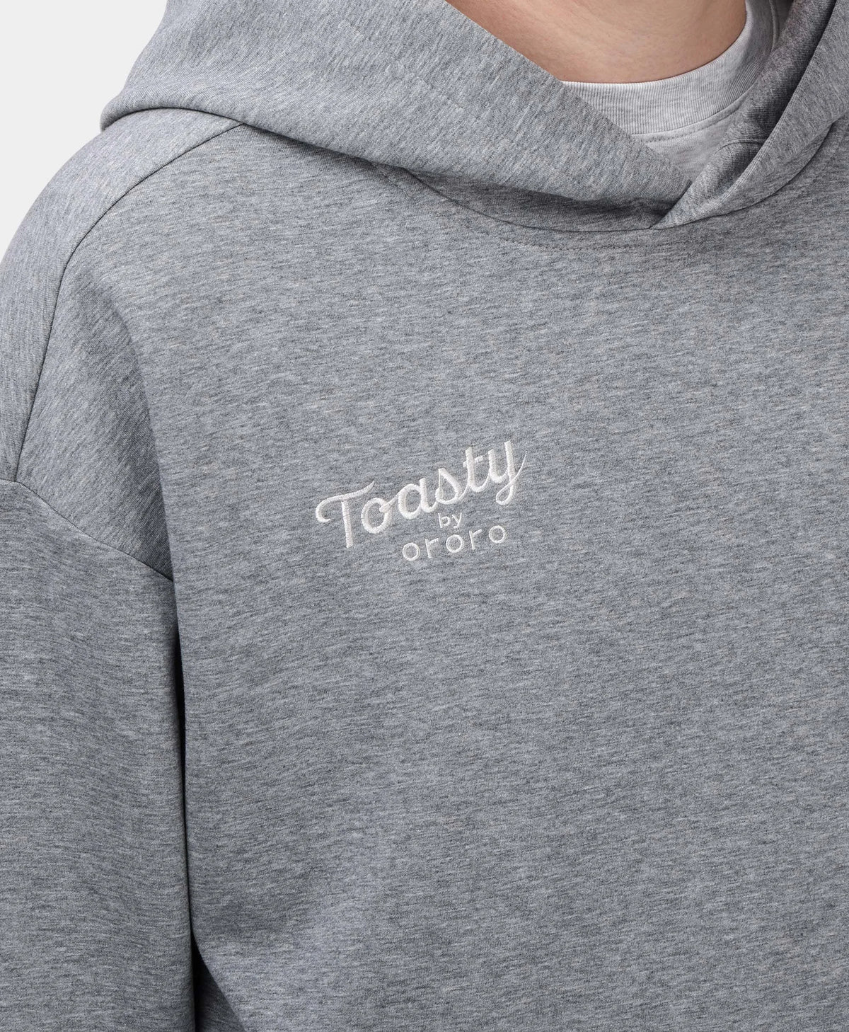 A flecking gray Toasty Unisex 5-Zone Heated Pullover Hoodie, featuring a close-up of the collar area and the white embroidered "Toasty by ororo" logo on the left chest.