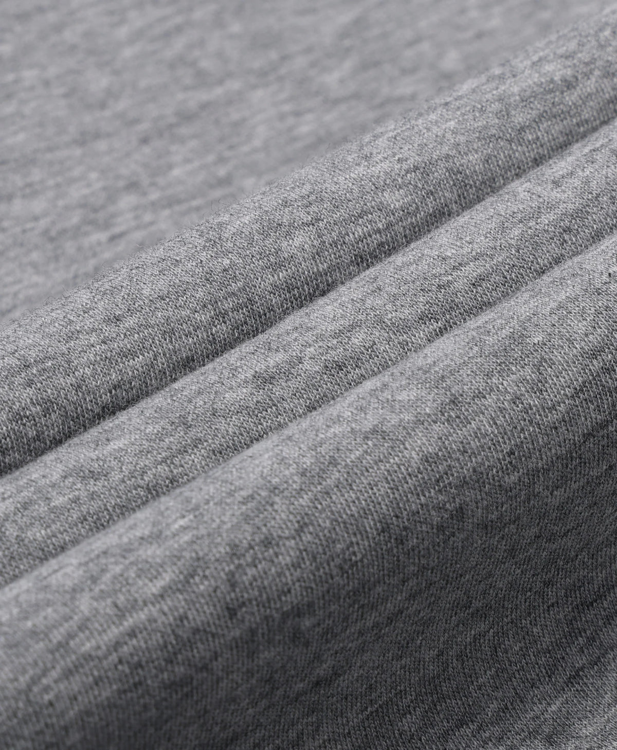 A flecking gray Toasty Unisex 5-Zone Heated Pullover Hoodie, displayed in a macro close-up of draped gray fabric with soft diagonal folds showing a fine woven texture.