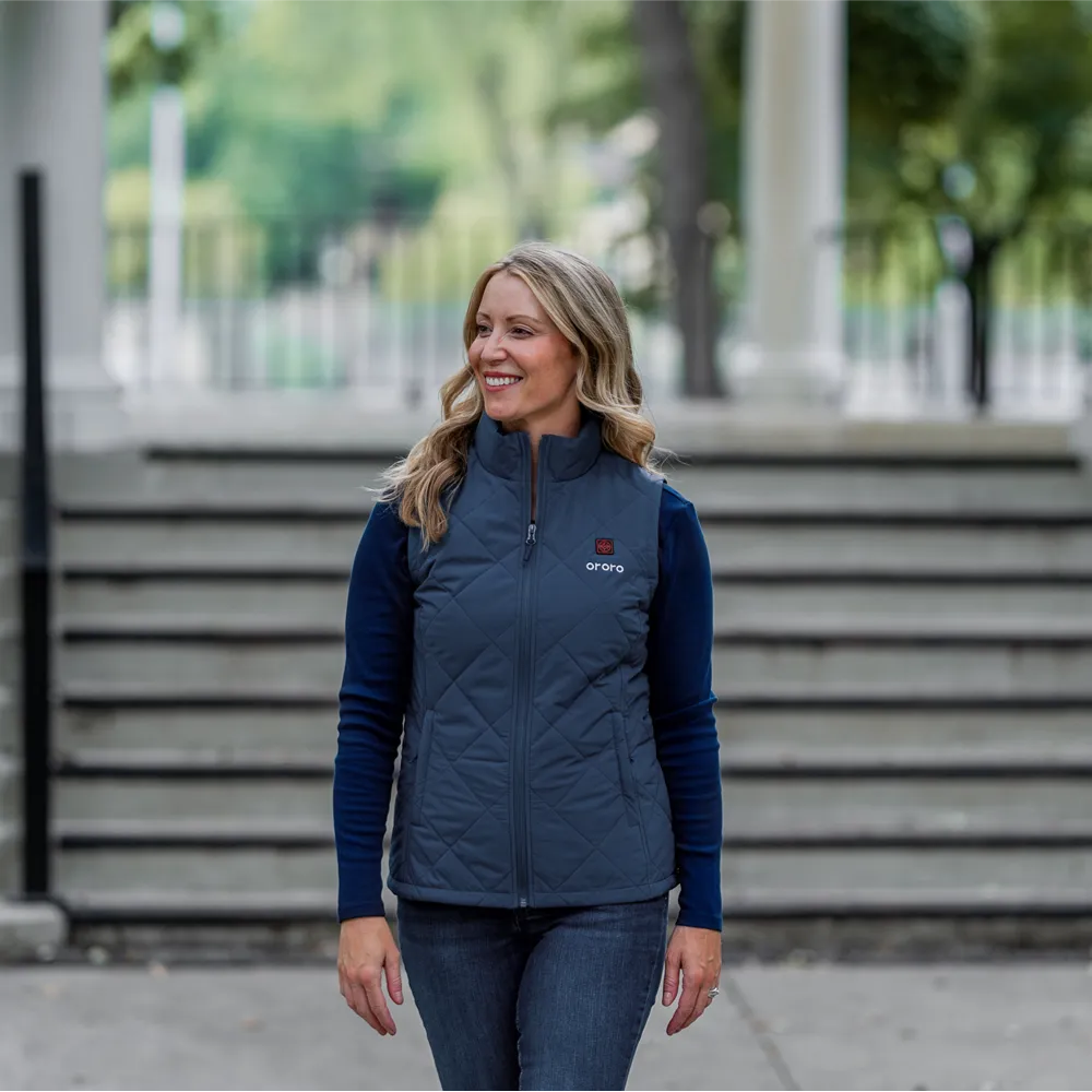 A woman wearing a ororo navy blue quilted vest over a dark blue long-sleeve shirt
